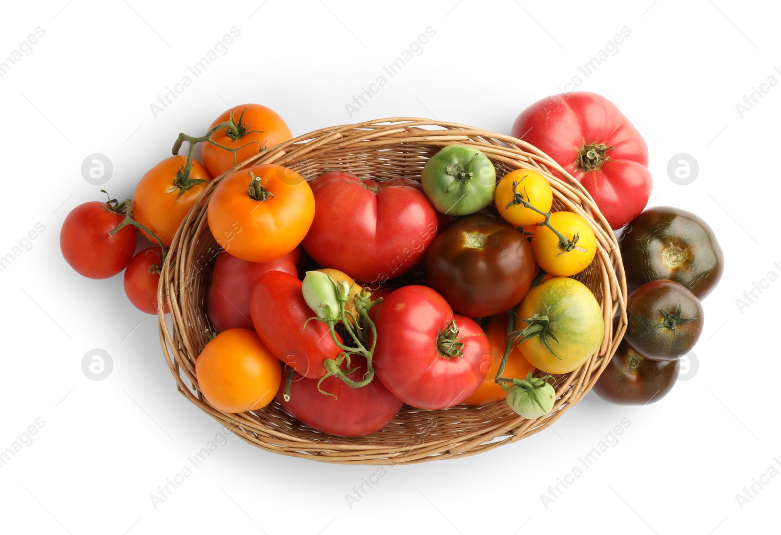 Photo of Different ripe tomatoes in basket isolated on white, top view