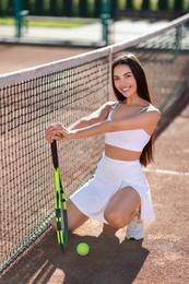 Beautiful woman with tennis racket on court