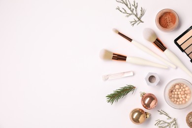 Photo of Different makeup brushes, decorative cosmetics and Christmas decor on white background, flat lay. Space for text