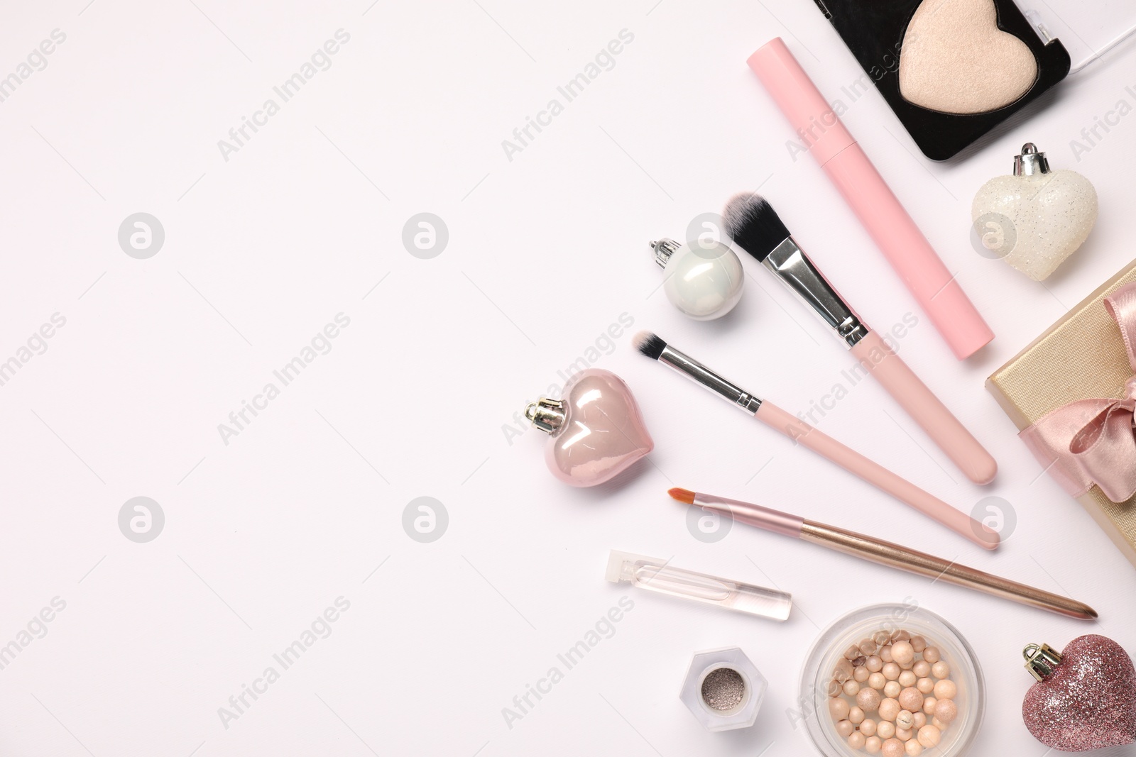 Photo of Different makeup brushes, decorative cosmetics and Christmas decor on white background, flat lay. Space for text