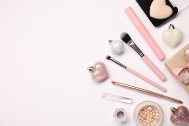 Photo of Different makeup brushes, decorative cosmetics and Christmas decor on white background, flat lay. Space for text