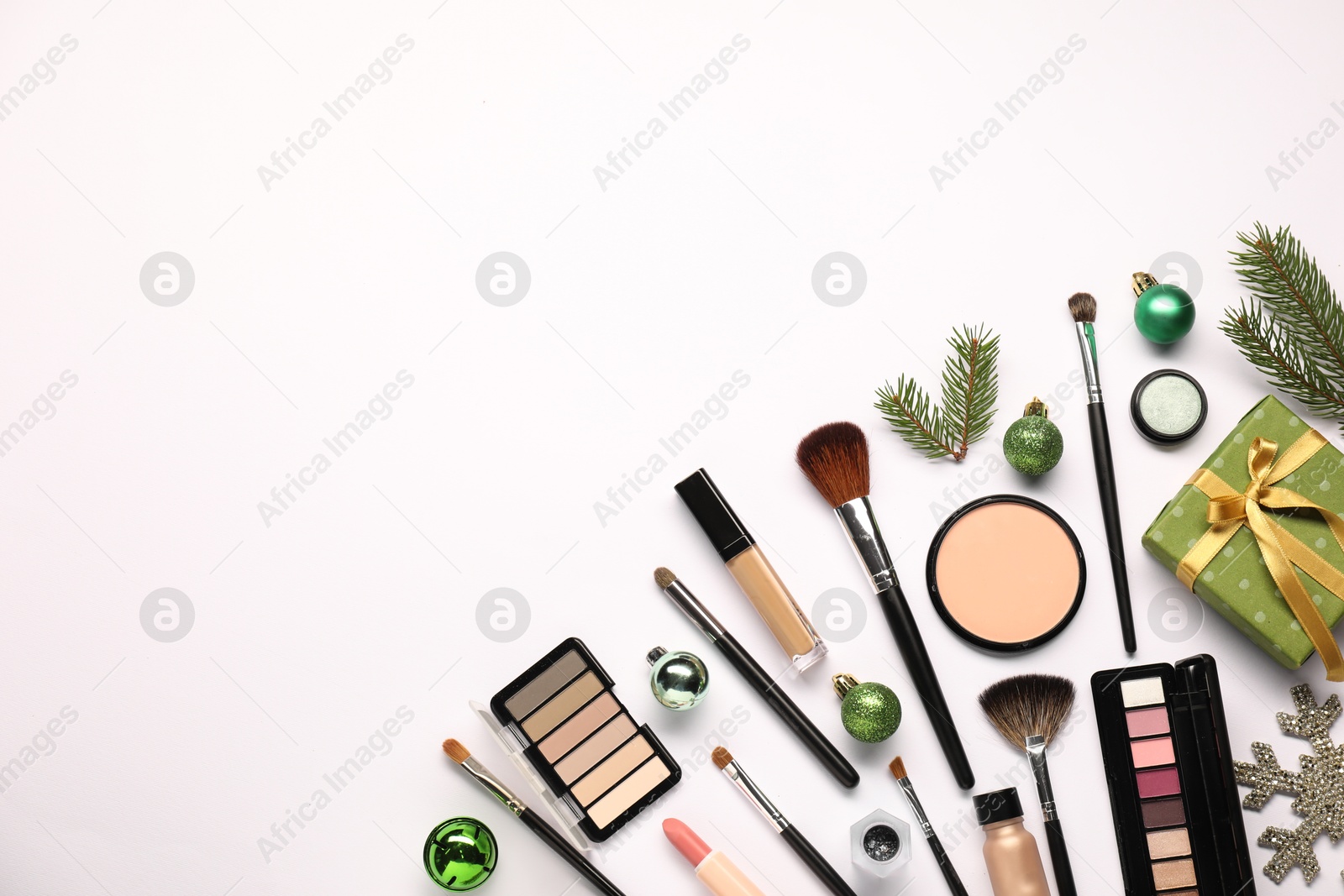 Photo of Different makeup brushes, decorative cosmetics and Christmas decor on white background, flat lay. Space for text