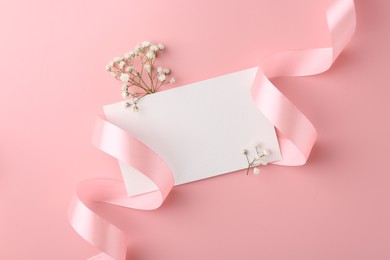 Flat lay composition with blank card, gypsophila flowers and ribbons on pink background