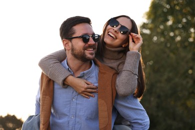 Photo of Beautiful couple having fun together in autumn park, low angle view