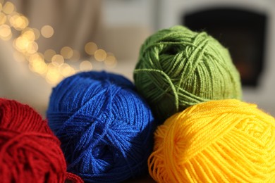 Photo of Many colorful yarns against blurred lights, closeup