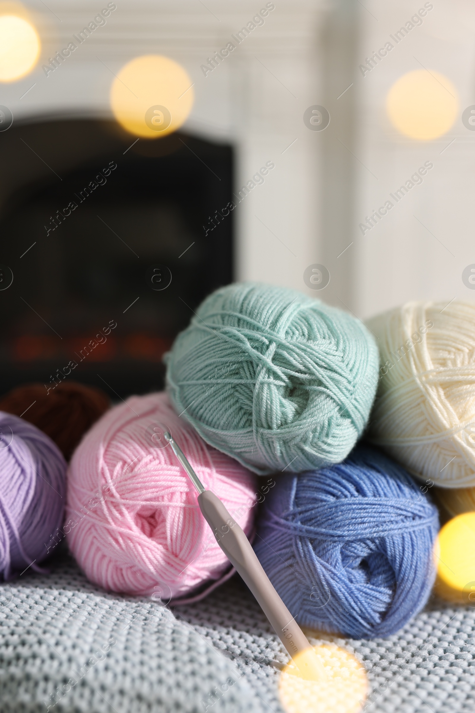 Photo of Many colorful yarns on blanket among blurred lights