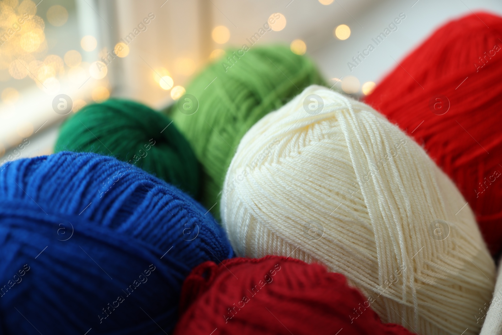 Photo of Many colorful yarns on blurred background, closeup