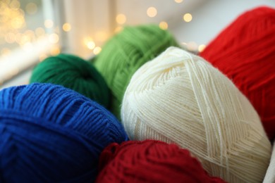 Photo of Many colorful yarns on blurred background, closeup