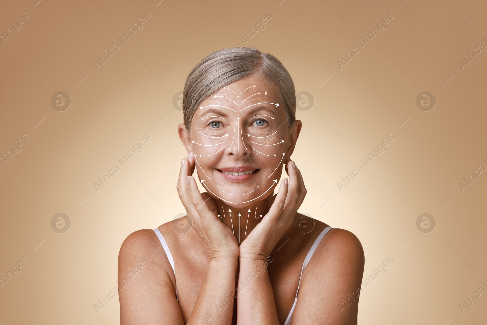 Image of Beautiful woman with healthy skin on dark beige background. Arrows on face showing direction of massage moves