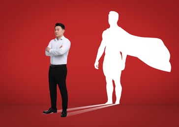 Inner superhero revealing powerful, skillful and determined personality. Confident businessman and white silhouette with cape on red background