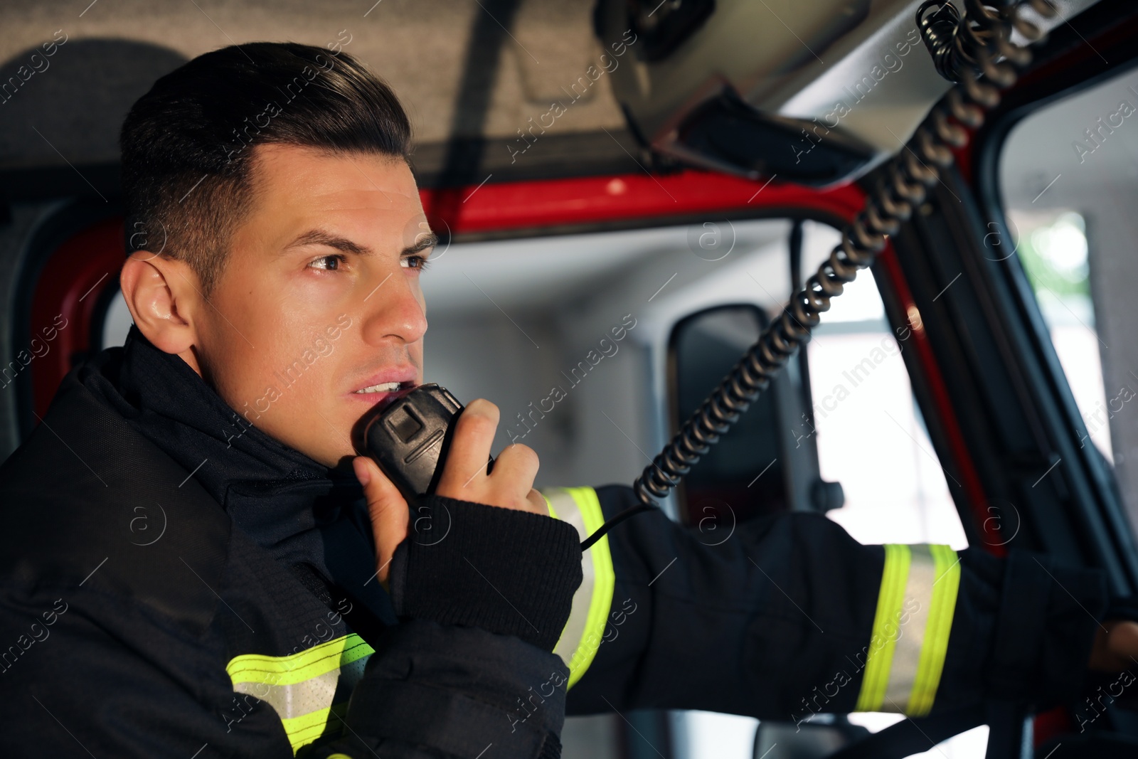 Photo of Firefighter using radio set while driving fire truck