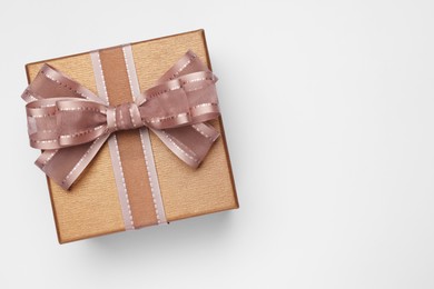 Photo of Gift box with bow on light grey background, top view. Space for text