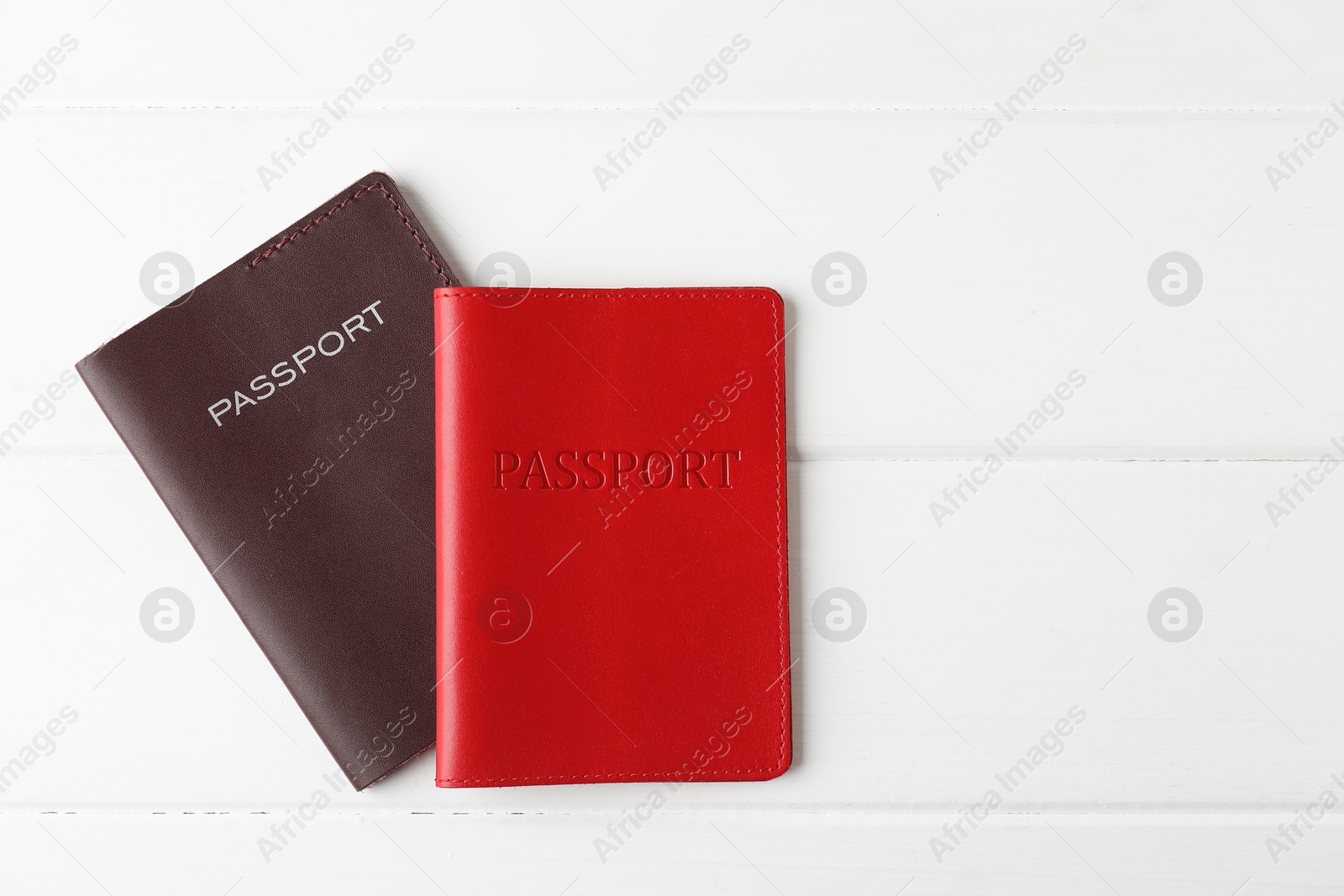 Photo of Passports on white wooden table, flat lay. Space for text