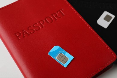 Photo of Passports and SIM cards on white table, closeup