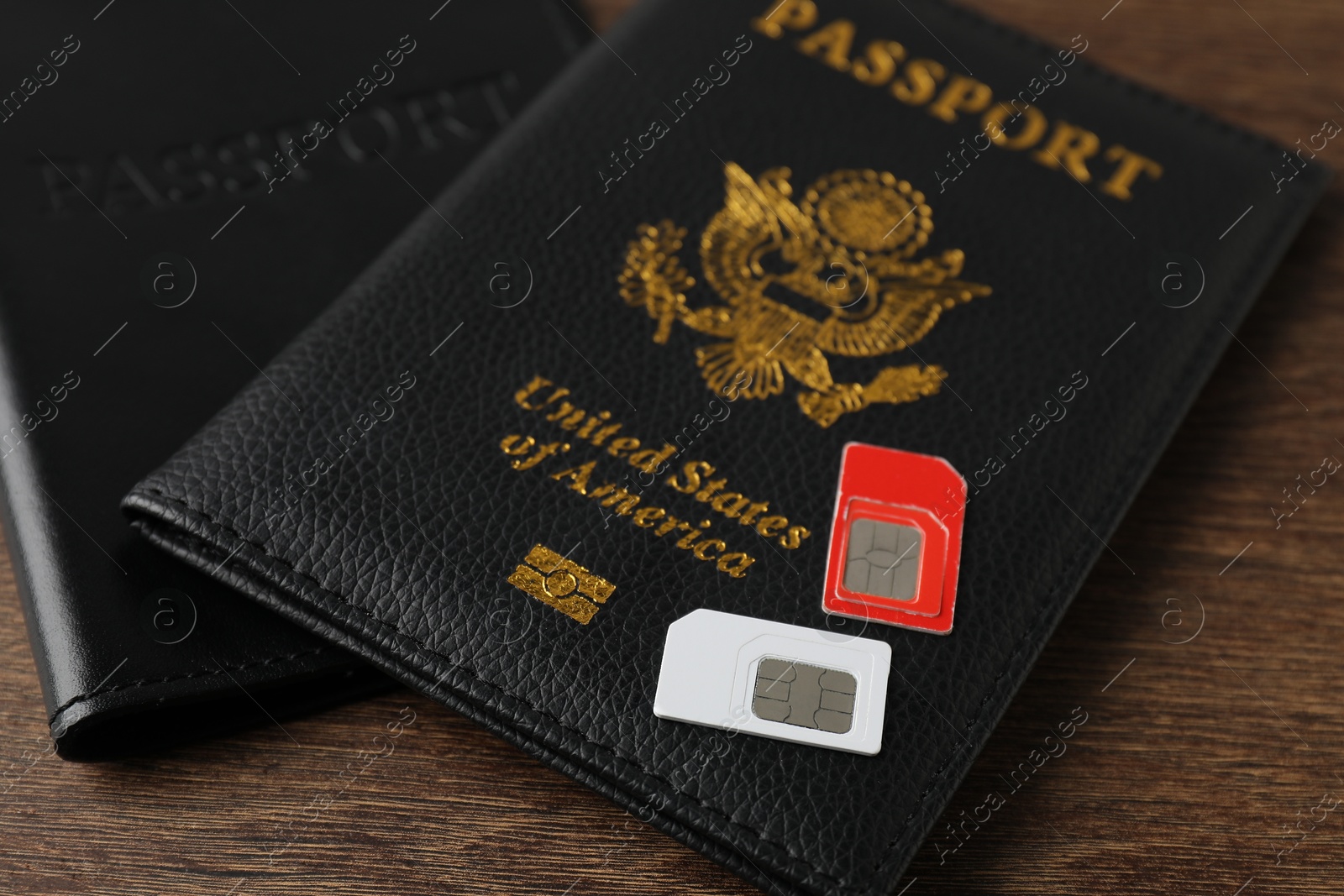 Photo of Passports and SIM cards on wooden table, closeup