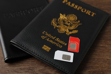 Photo of Passports and SIM cards on wooden table, closeup