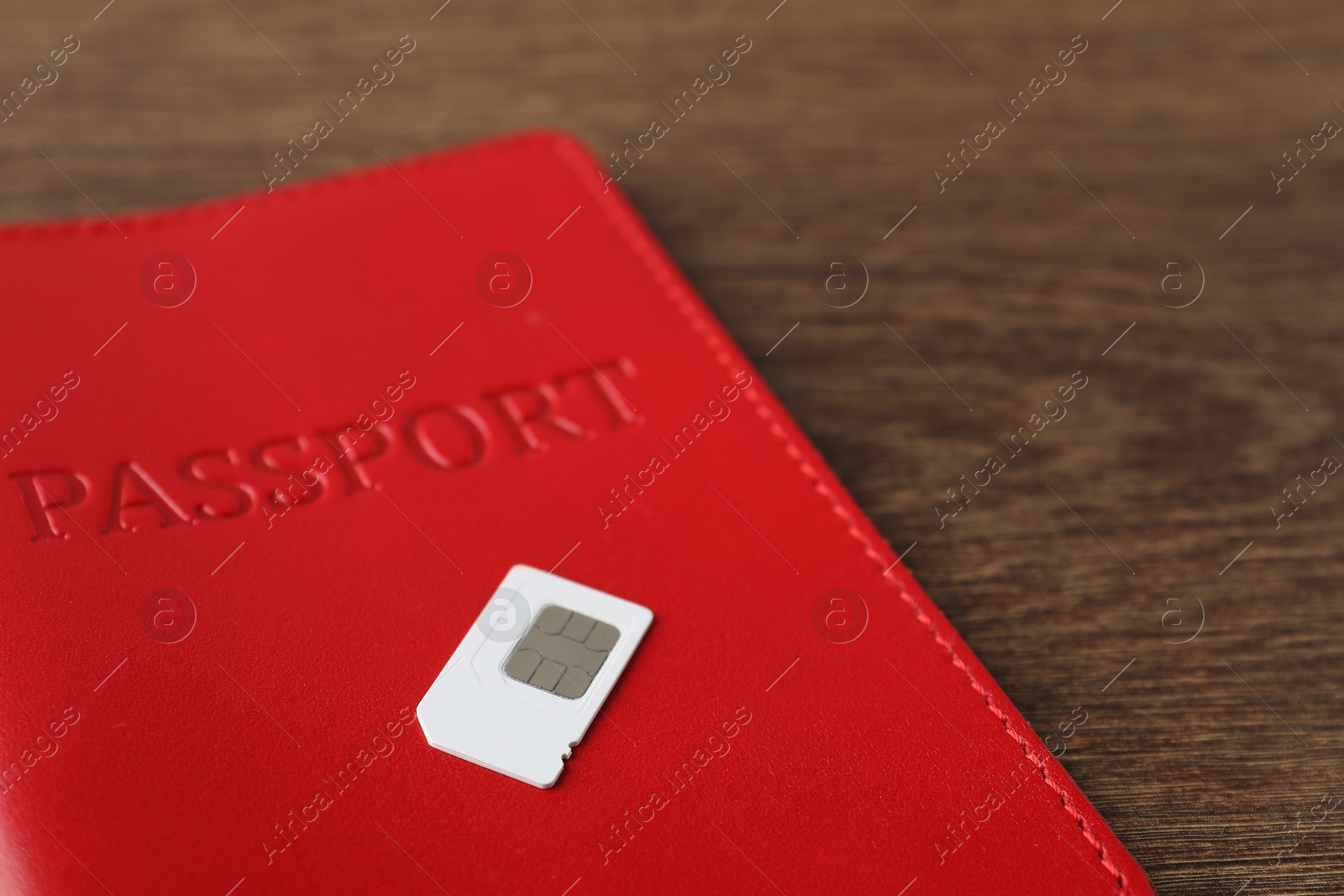 Photo of Passport and SIM card on wooden table, closeup