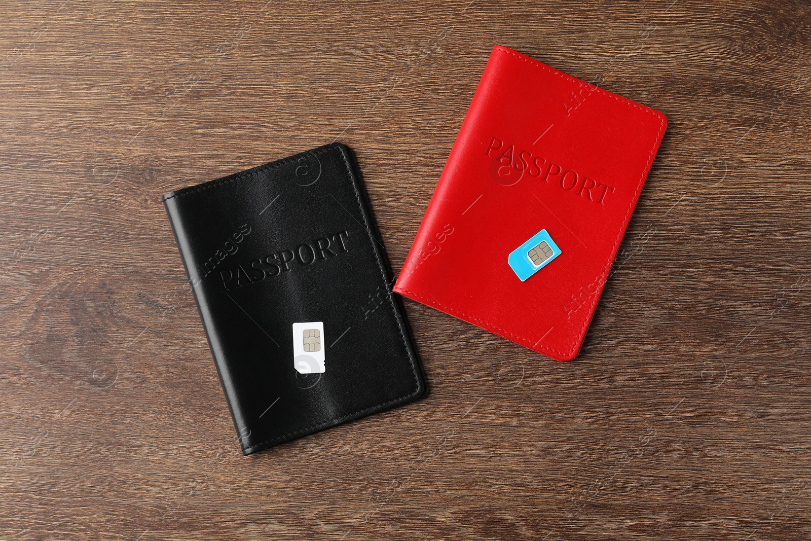 Photo of Passports and SIM cards on wooden table, flat lay