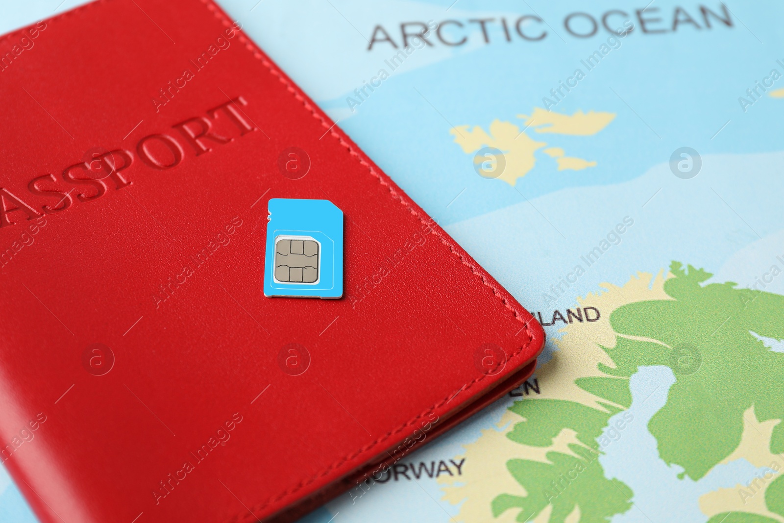 Photo of Passport and SIM card on world map, closeup