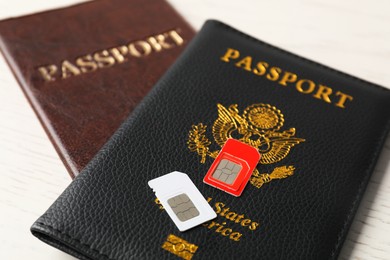 Photo of Passports and SIM cards on white table, closeup