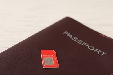 Photo of Passport and SIM card on white table, closeup