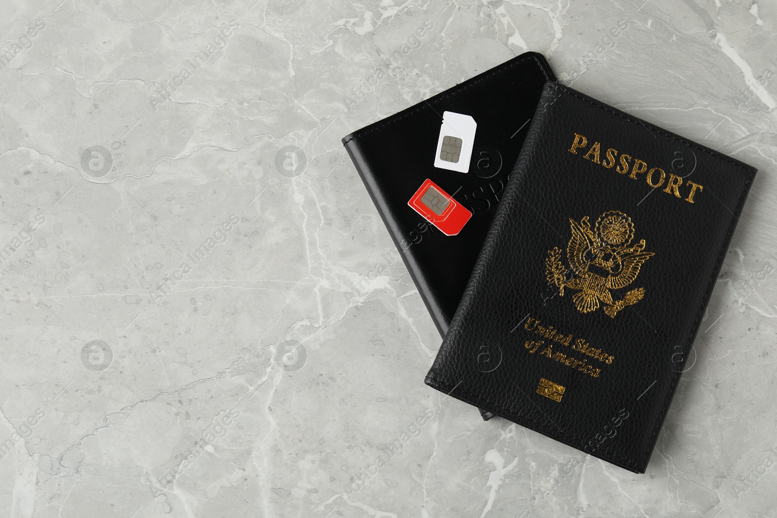 Photo of Passports and SIM cards on grey marble table, flat lay. Space for text