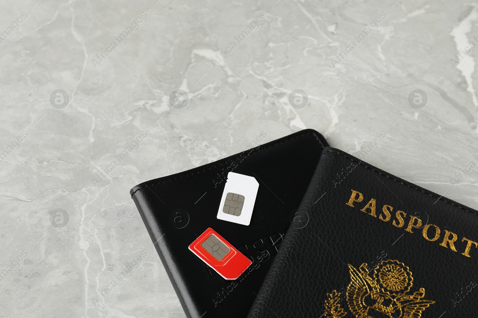 Photo of Passports and SIM cards on grey marble table