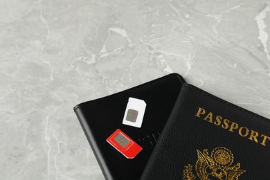 Passports and SIM cards on grey marble table