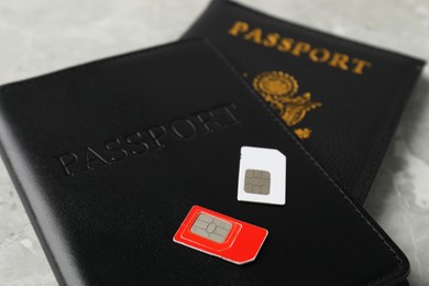 Photo of Passports and SIM cards on grey table, closeup