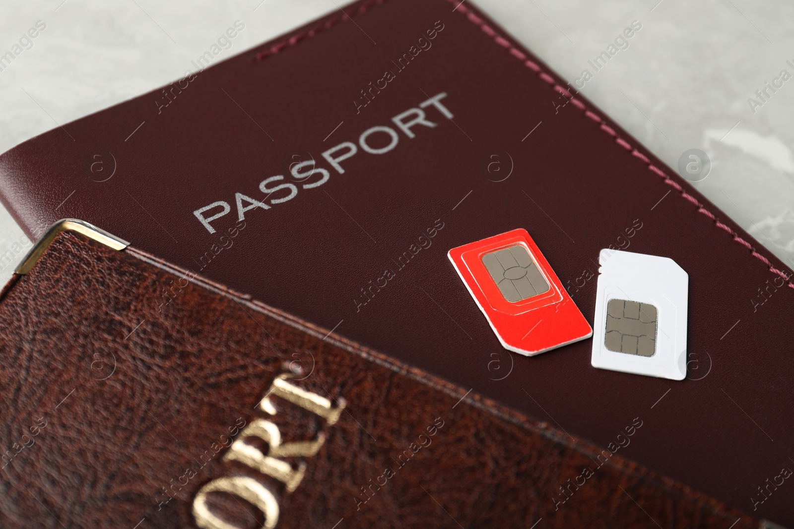 Photo of Passports and SIM cards on grey table, closeup