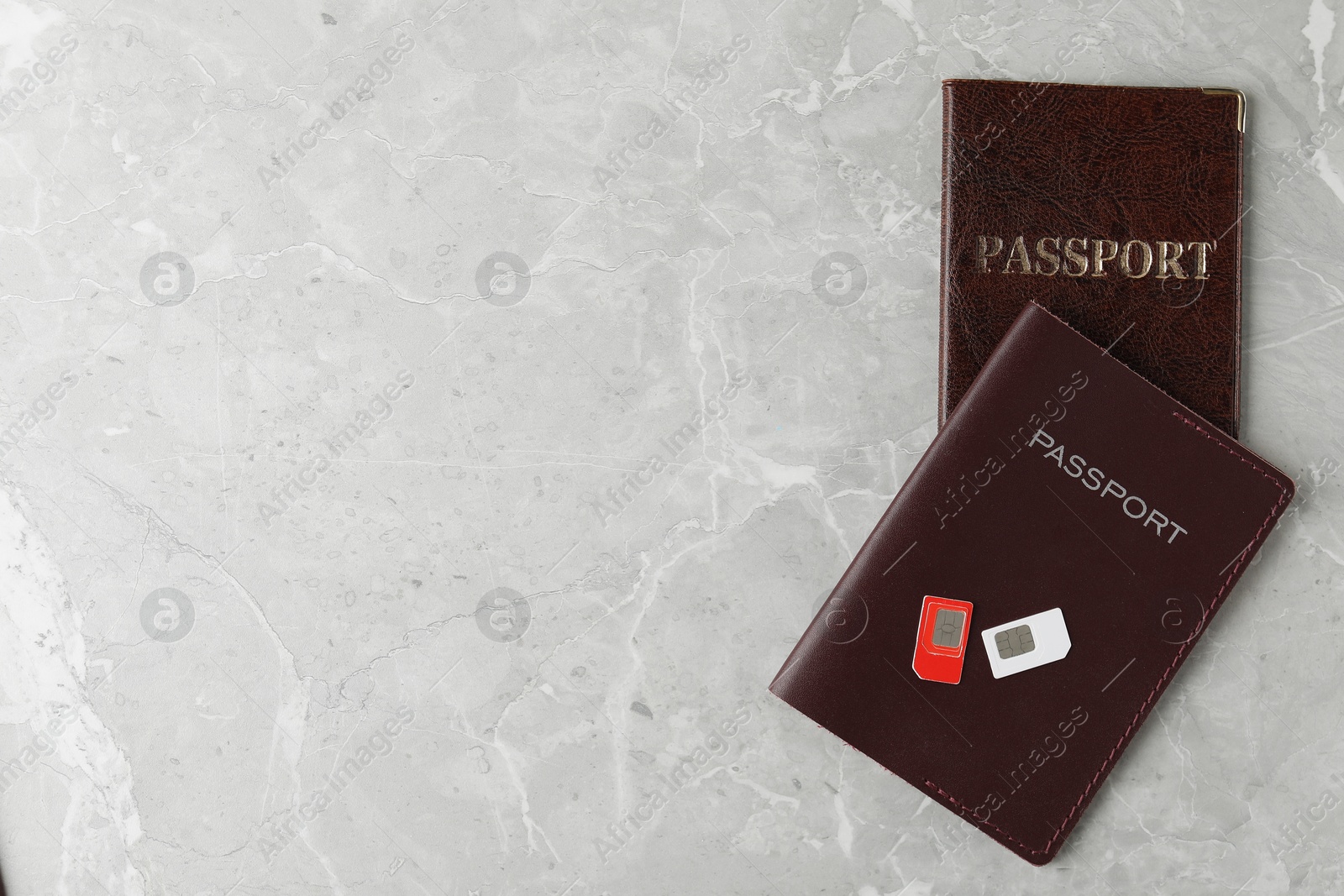 Photo of Passports and SIM cards on grey marble table, flat lay. Space for text