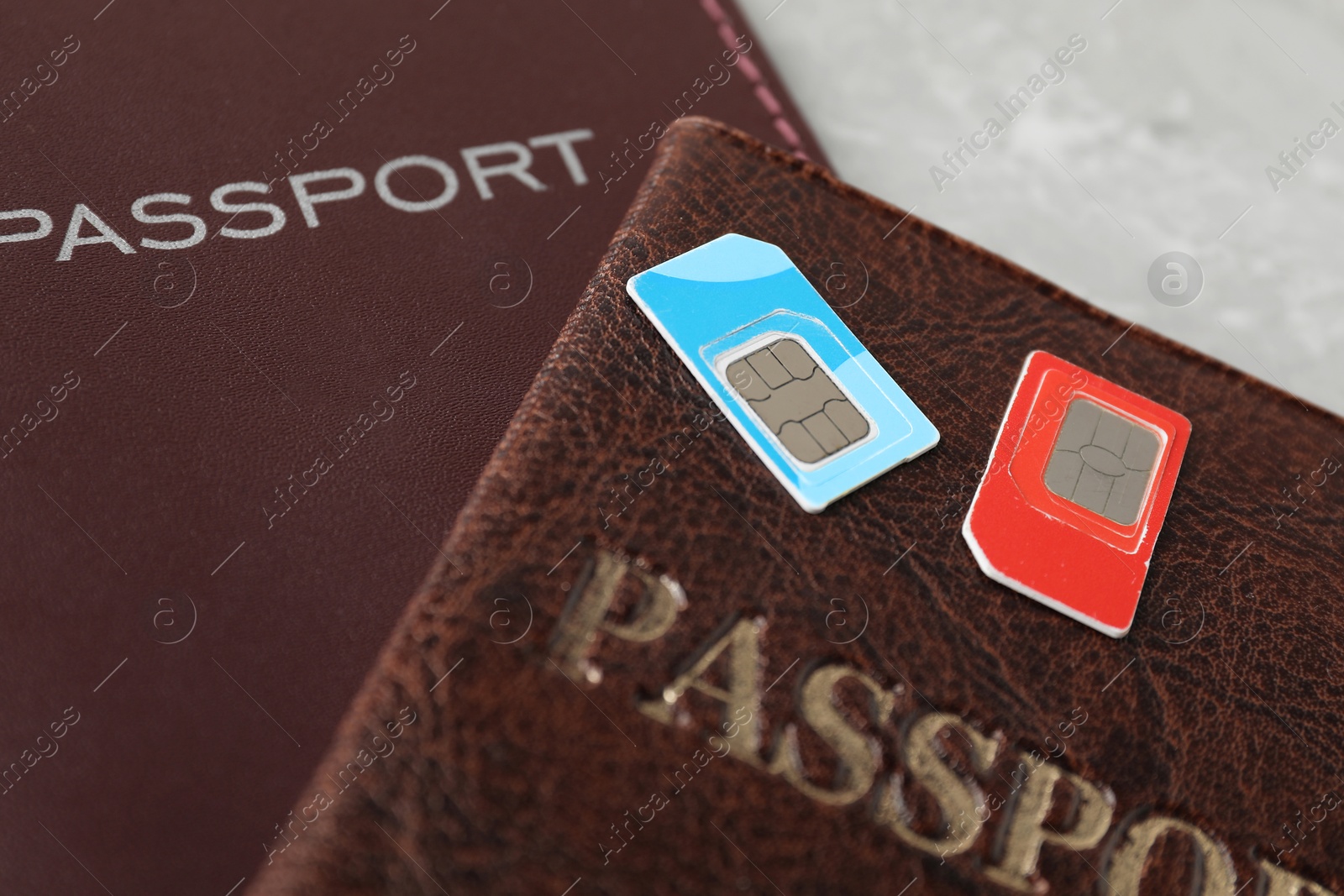 Photo of Passports and SIM cards on grey table, closeup