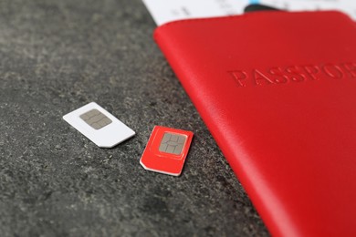 Photo of Passport and SIM cards on grey textured table, closeup