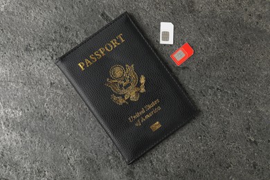 Passport and SIM cards on grey textured table, flat lay