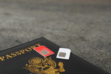 Photo of Passport and SIM cards on grey table, closeup