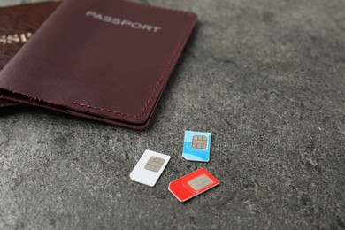 Photo of Passports and SIM cards on grey textured table, closeup