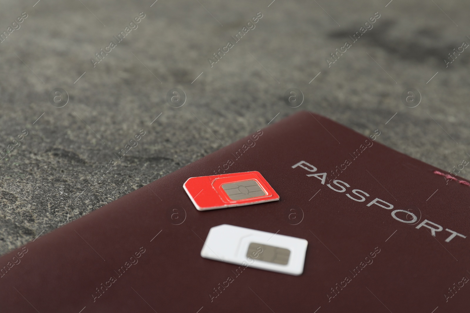 Photo of Passport and SIM cards on grey table, closeup