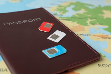 Photo of SIM cards and passport on world map, closeup