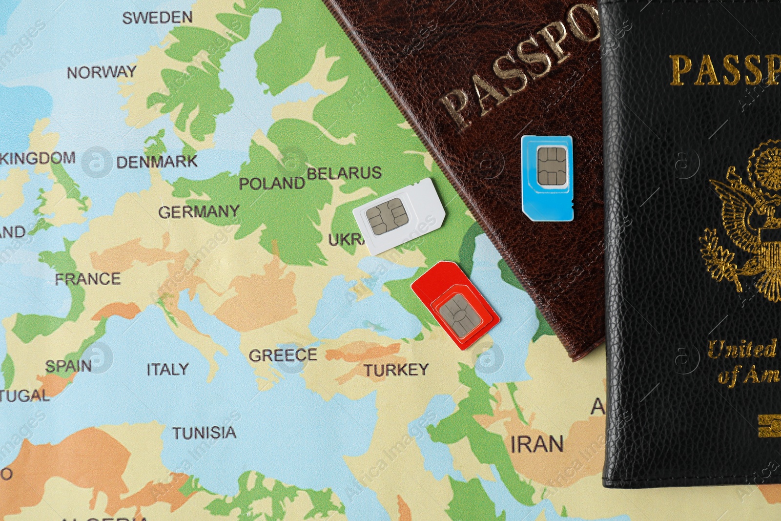 Photo of SIM cards and passports on world map, flat lay