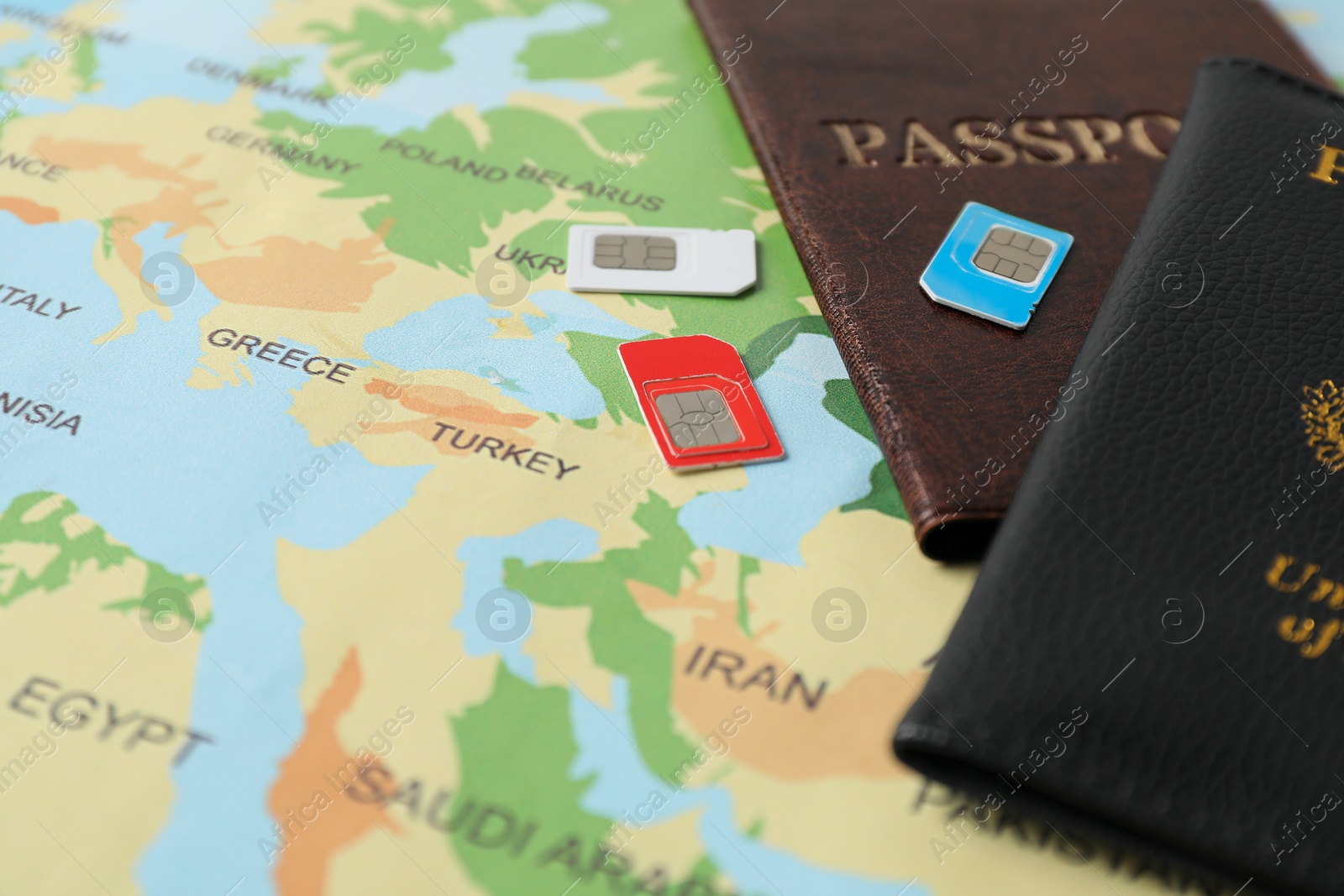 Photo of SIM cards and passports on world map, closeup