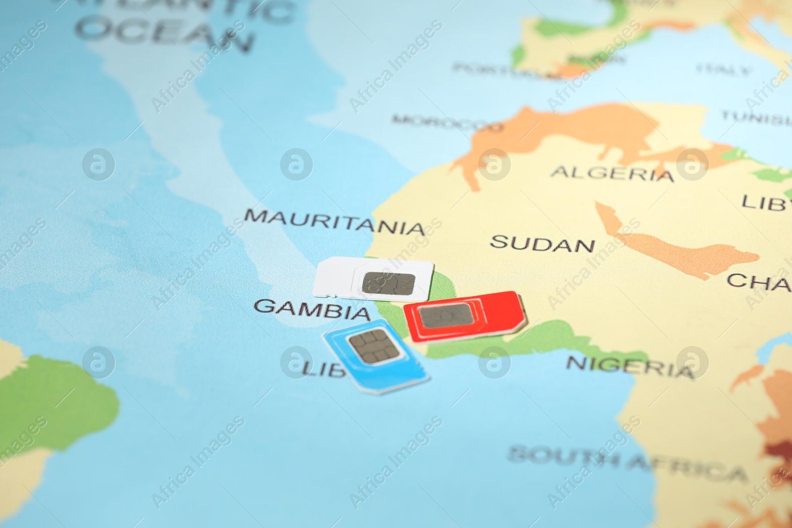 Photo of Modern SIM cards on world map, closeup