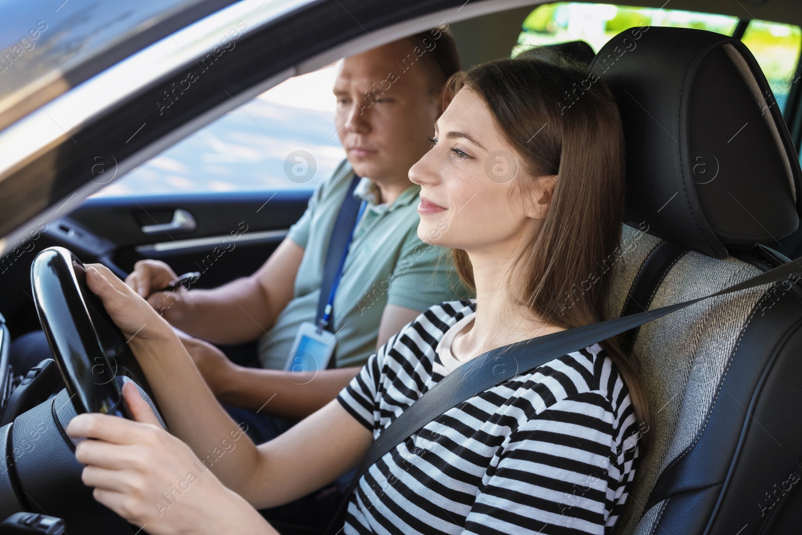 Photo of Driving school. Student passing driving test with examiner in car