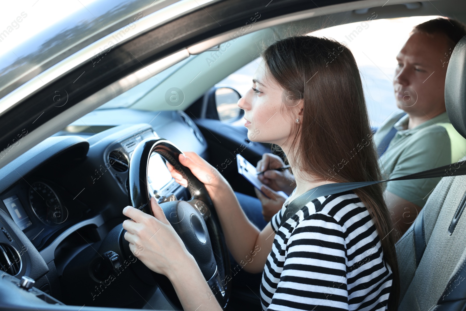 Photo of Driving school. Student passing driving test with examiner in car