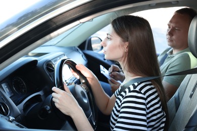 Driving school. Student passing driving test with examiner in car