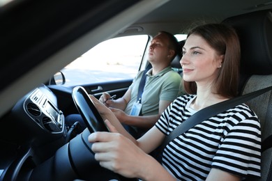 Driving school. Student passing driving test with examiner in car