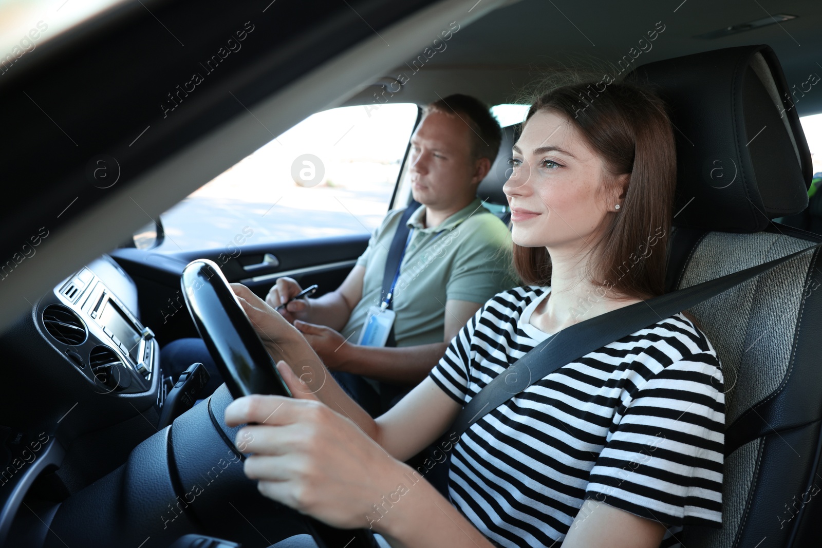 Photo of Driving school. Student passing driving test with examiner in car