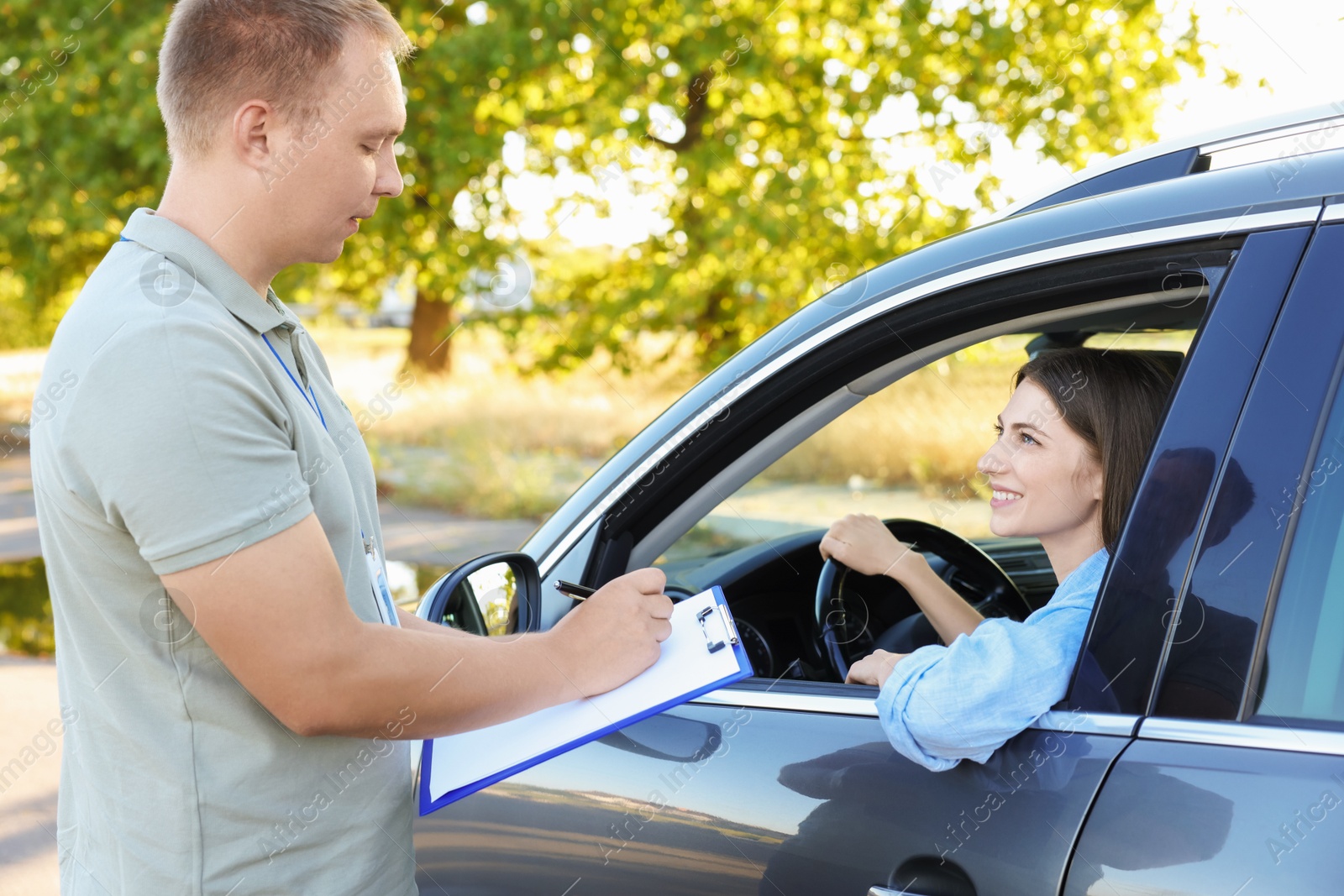 Photo of Examiner near car with student during test at driving school