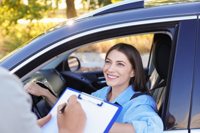 Photo of Examiner near car with student during test at driving school