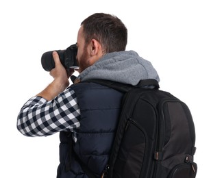 Photographer with backpack and camera taking picture on white background, back view