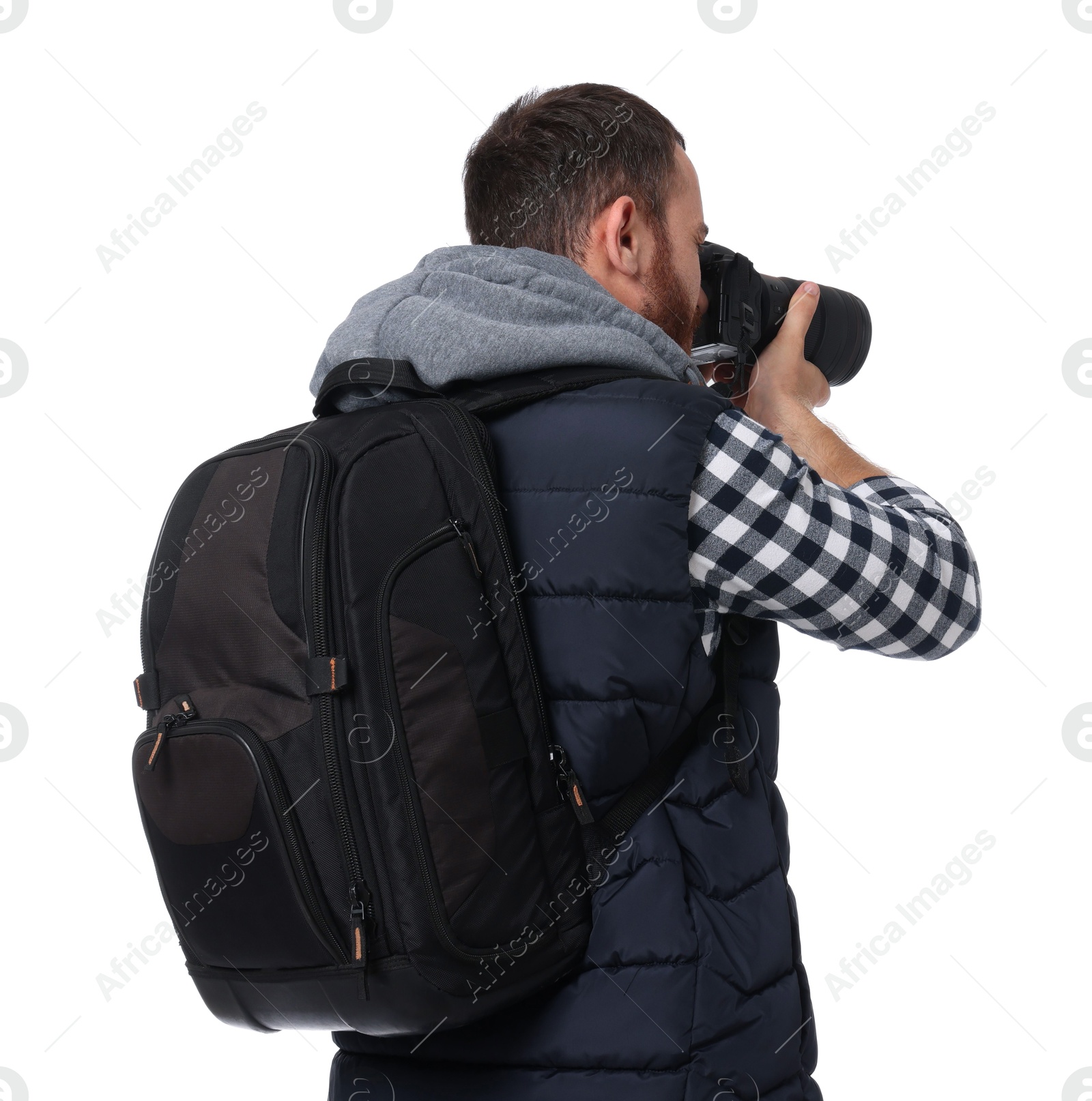 Photo of Photographer with backpack and camera taking picture on white background, back view